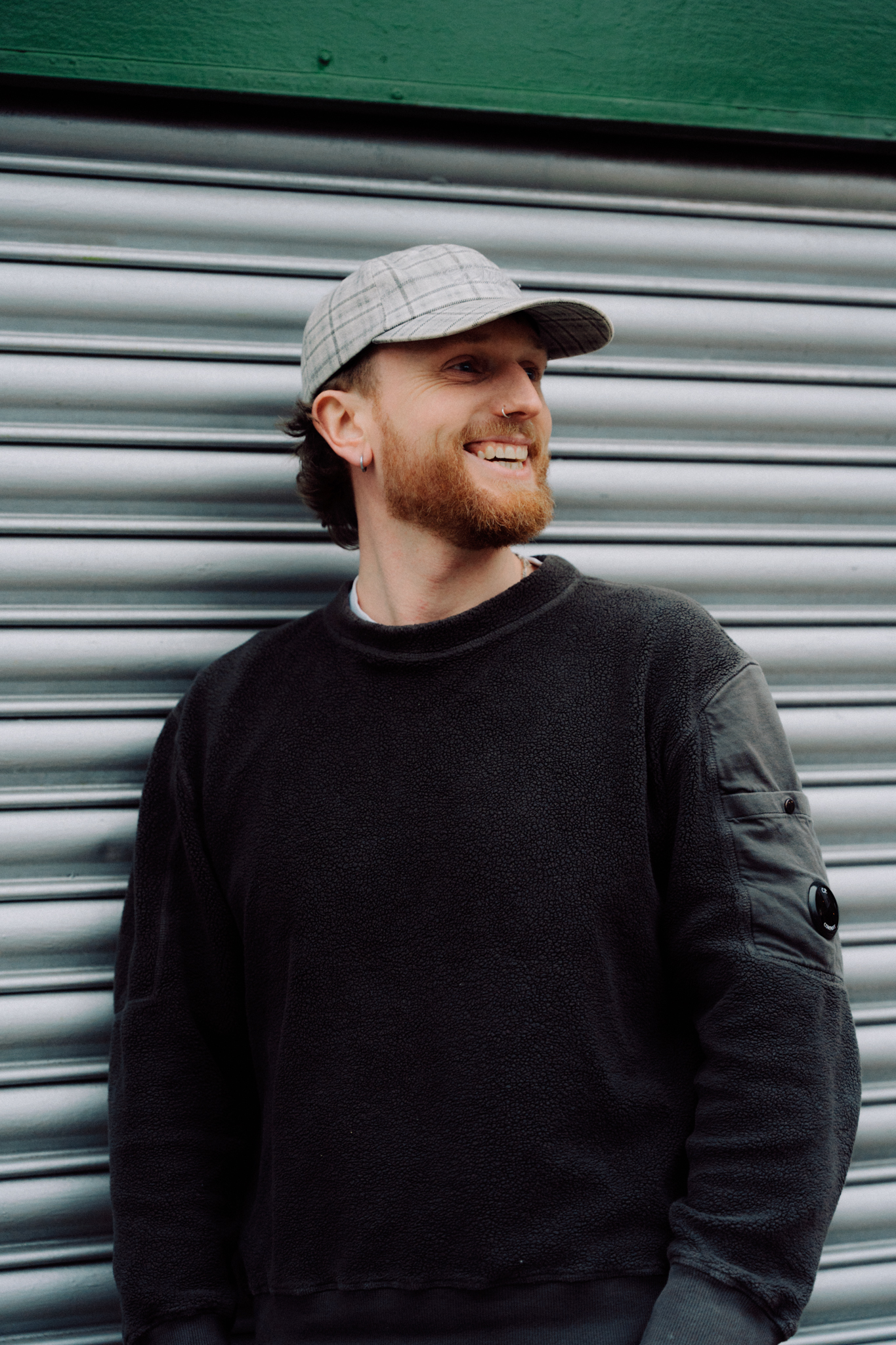 Connor Cooper in front of a steel roller door.