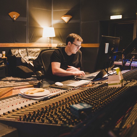Chris Taylor sat by a computer and mixing desk.