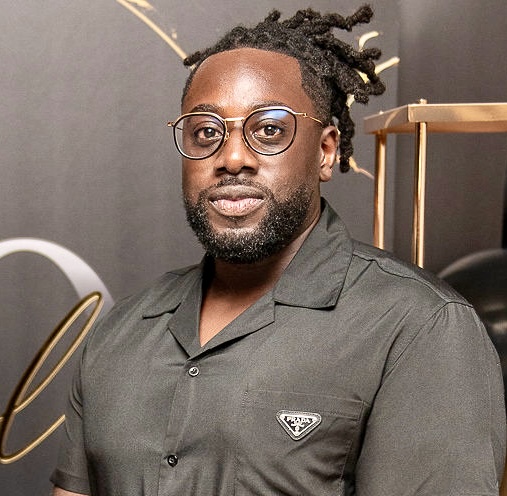 Des Agyekumhene in front of a media wall.