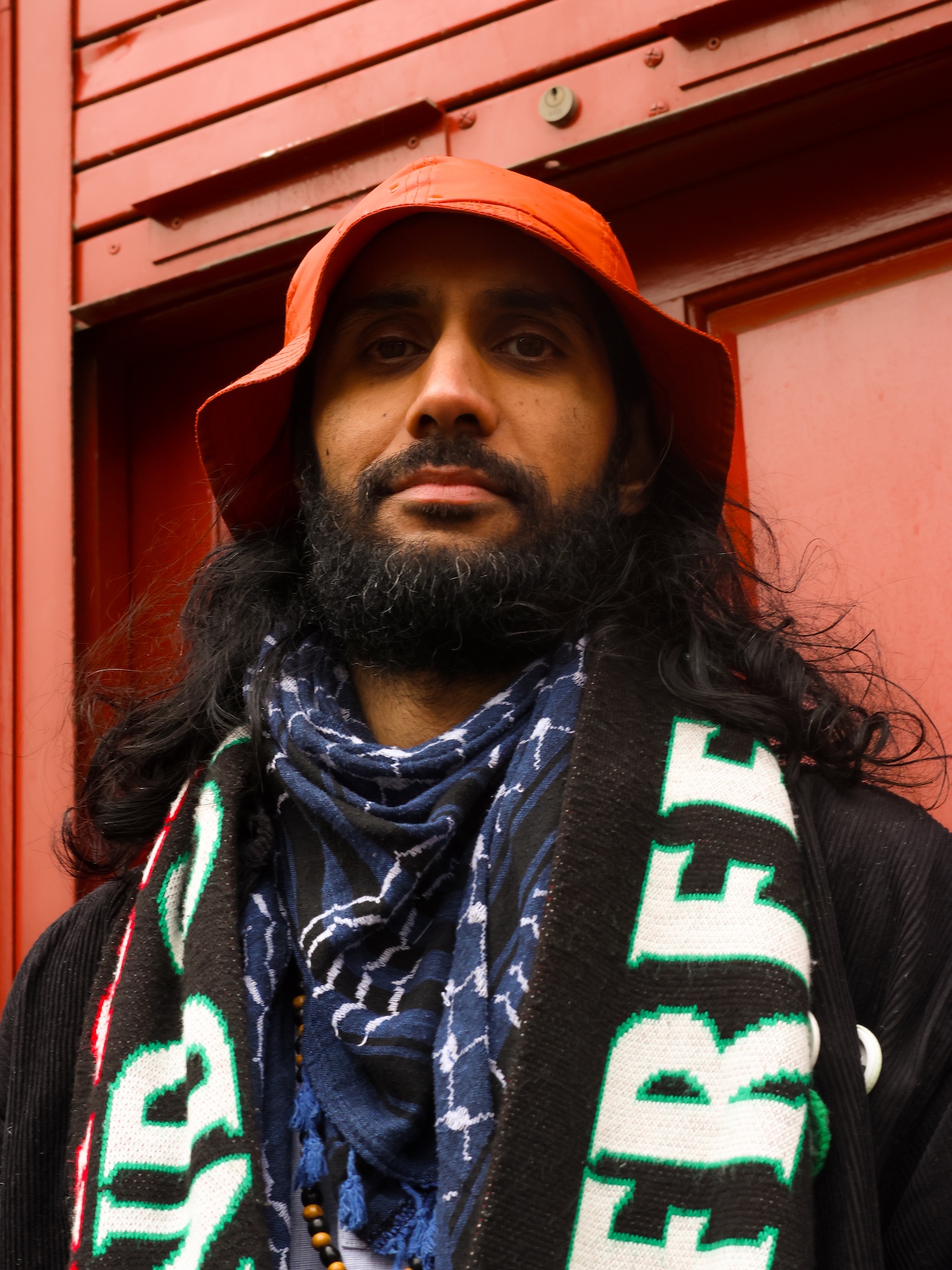 Balraj Samrai against a red door.