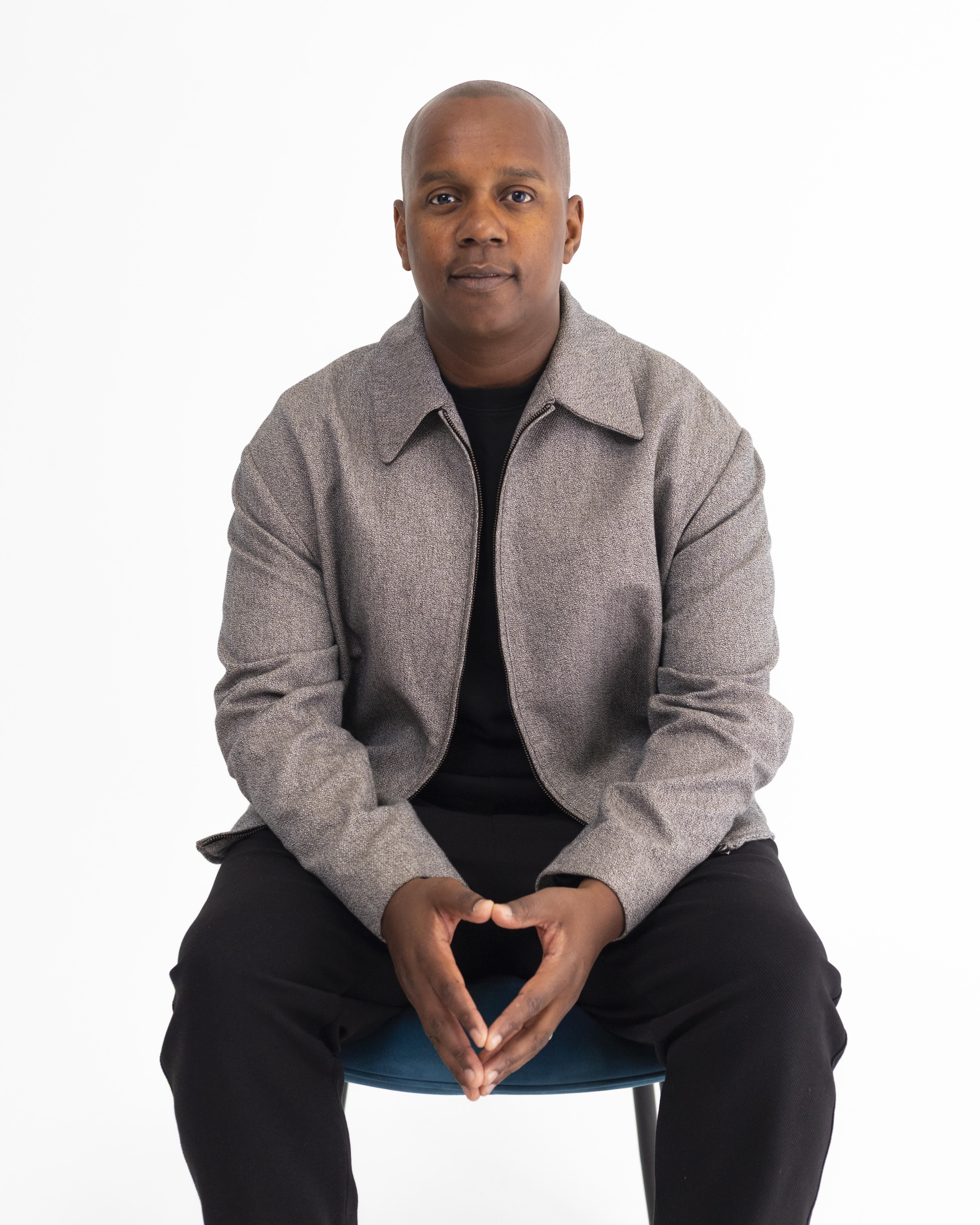 Rich Castillo sat on a chair in front of a white background.
