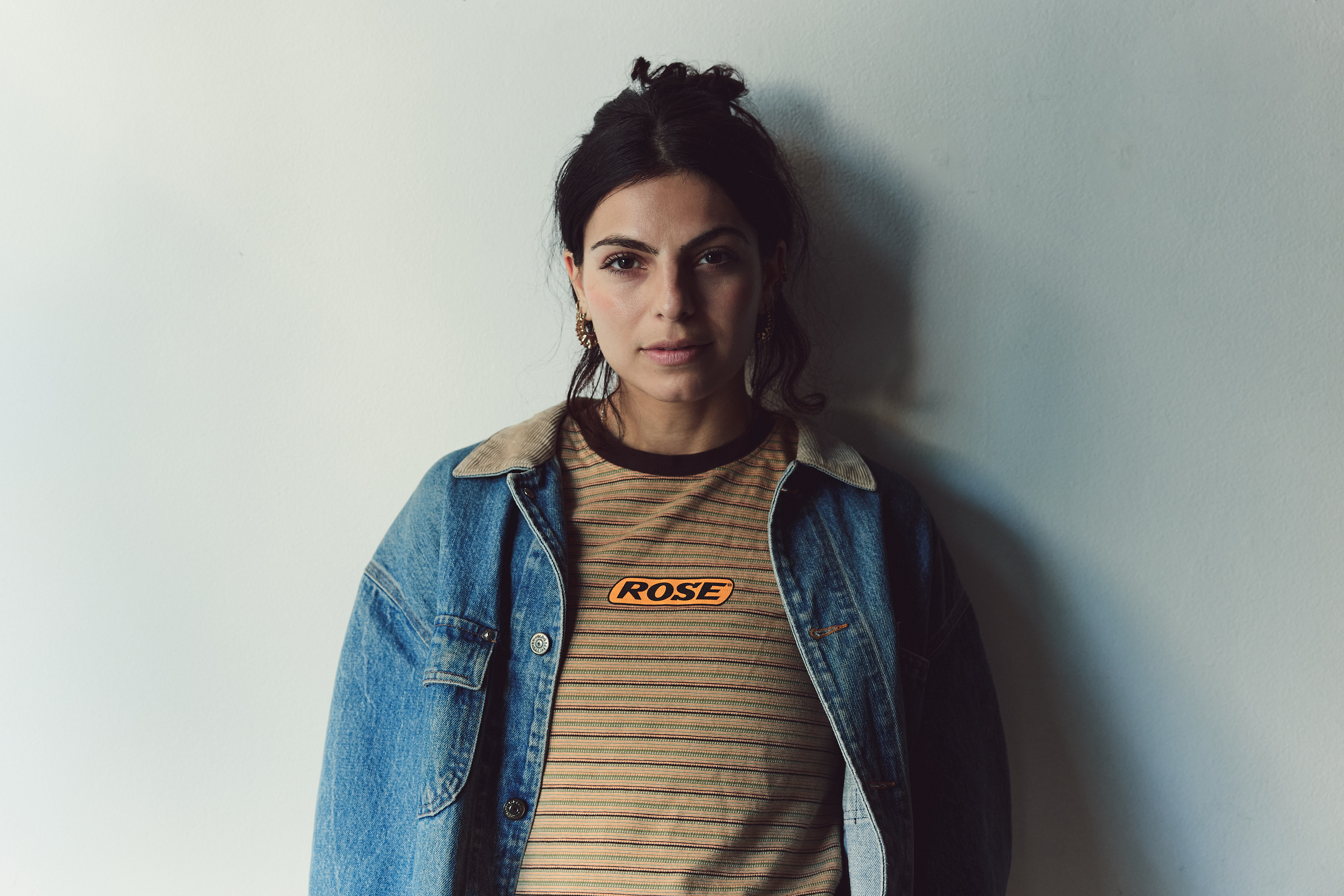 Sarah Dattani Tucker looking to camera against a white wall.