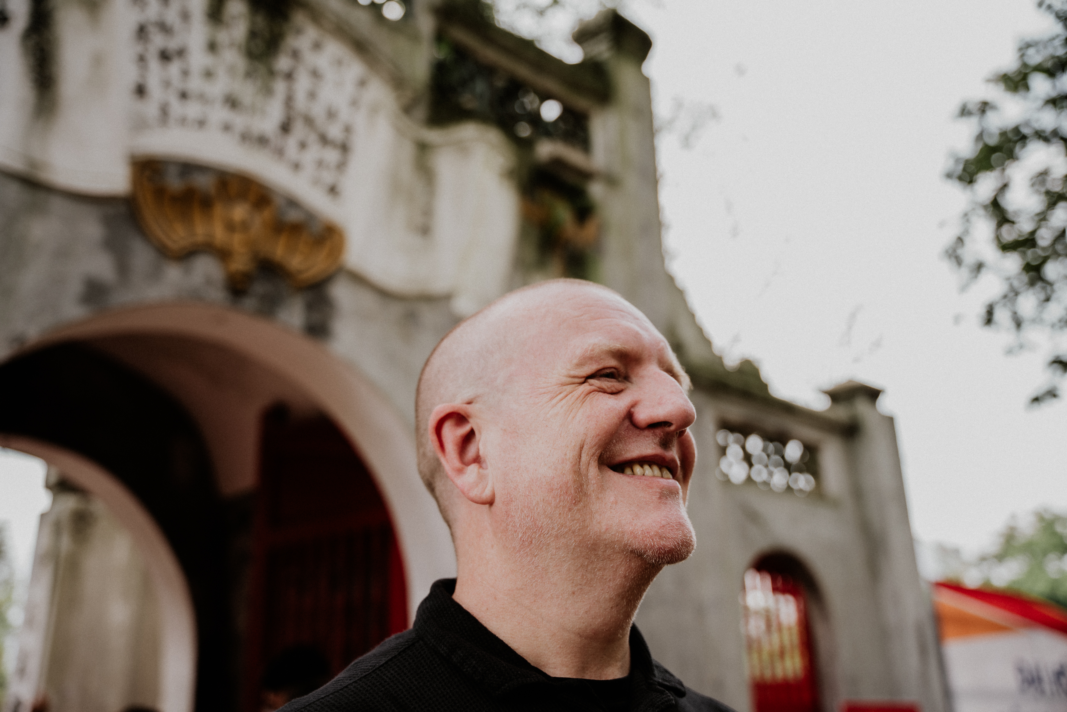 Zed Bias smiling outside in front of an archway.