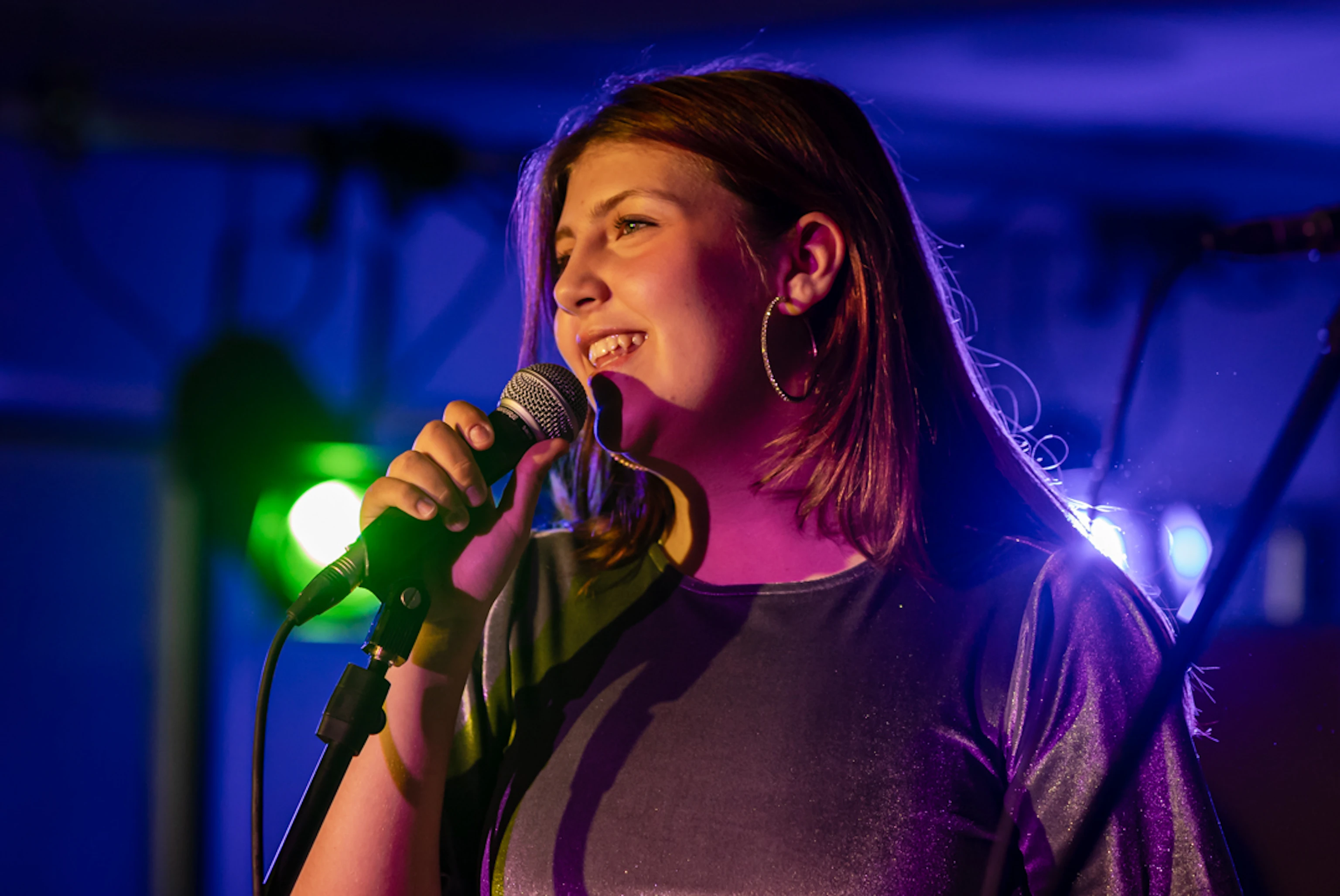 Young musician smiling with a microphone.