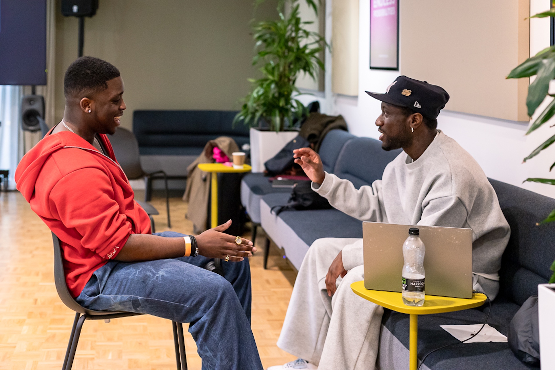 A young musician sat chatting with an industry professional.