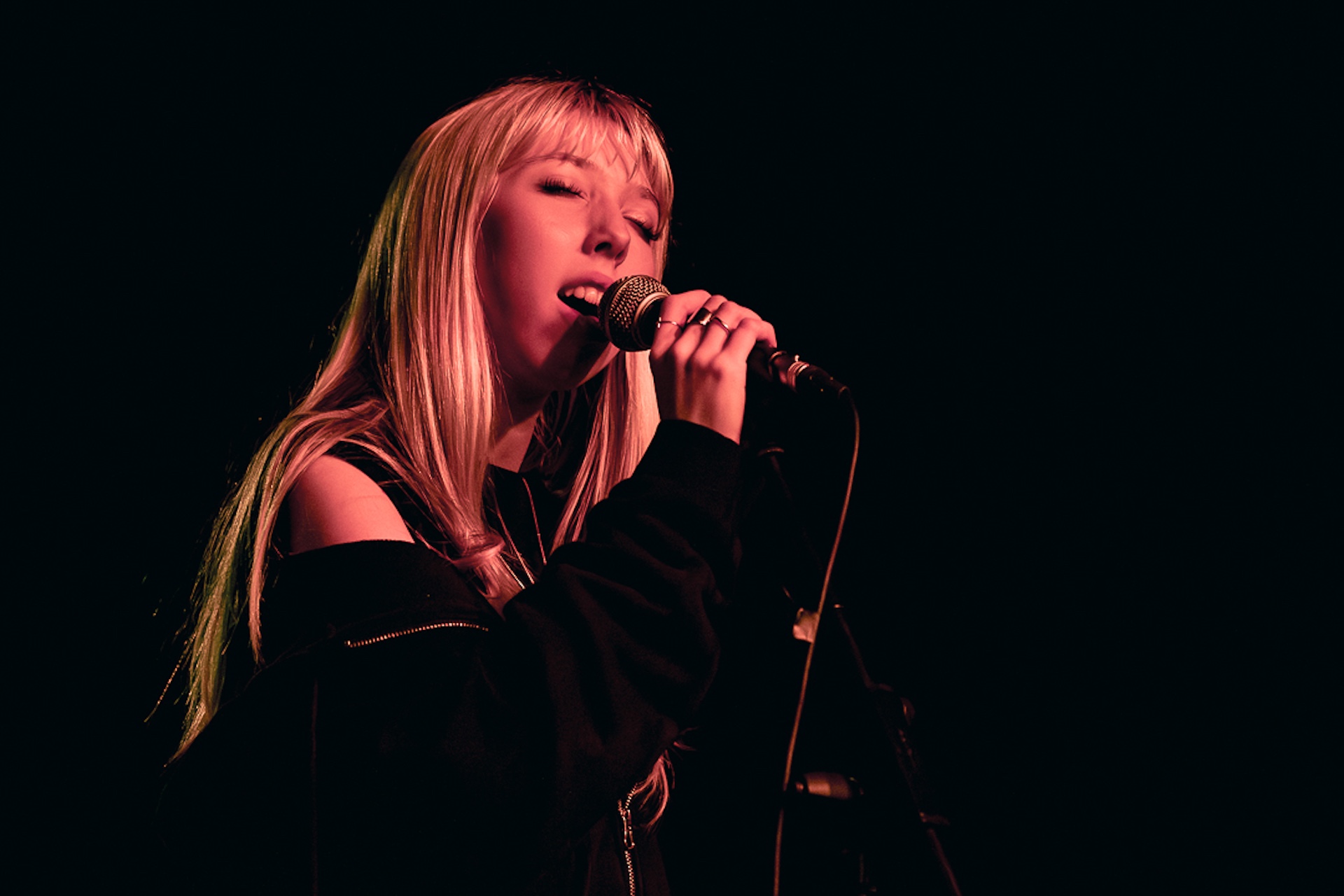 Musician singing into a mic.