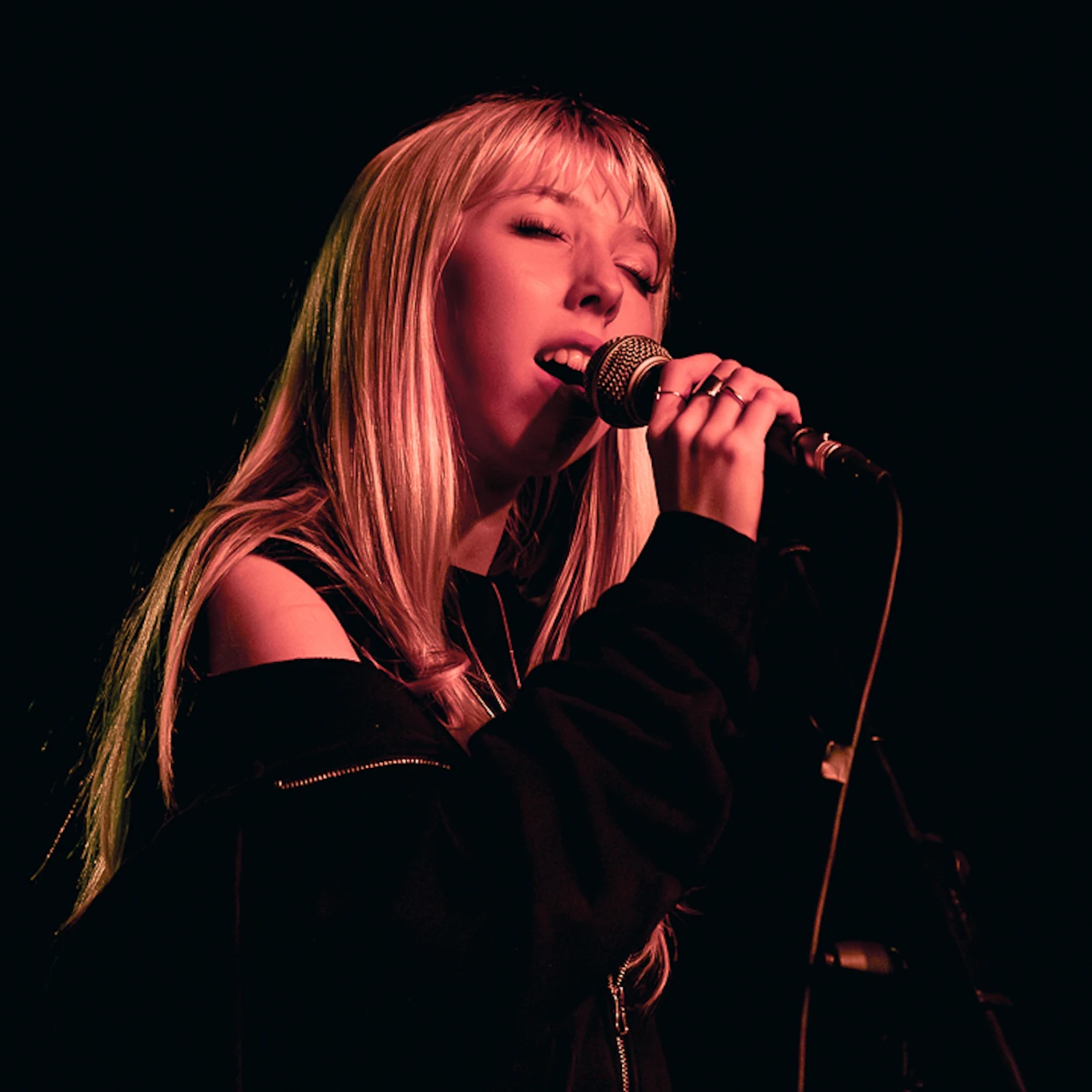 Musician singing into a mic.