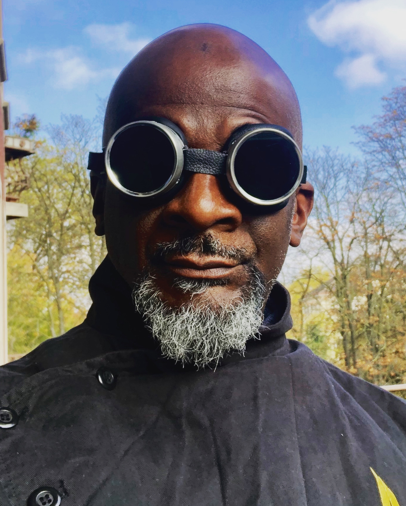 AbuQadim Haqq looking into the camera wearing steampunk goggles.