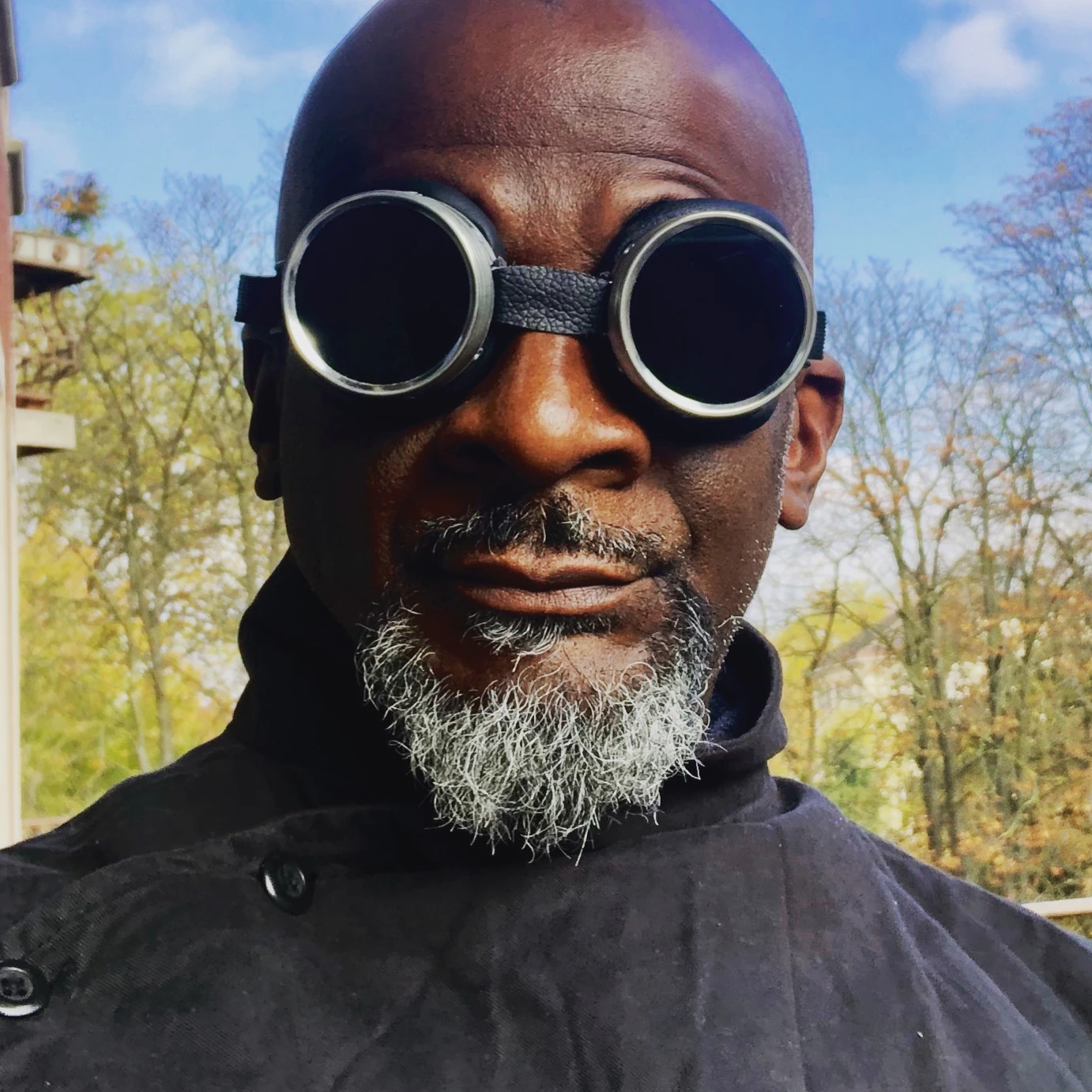 AbuQadim Haqq looking into the camera wearing steampunk goggles.