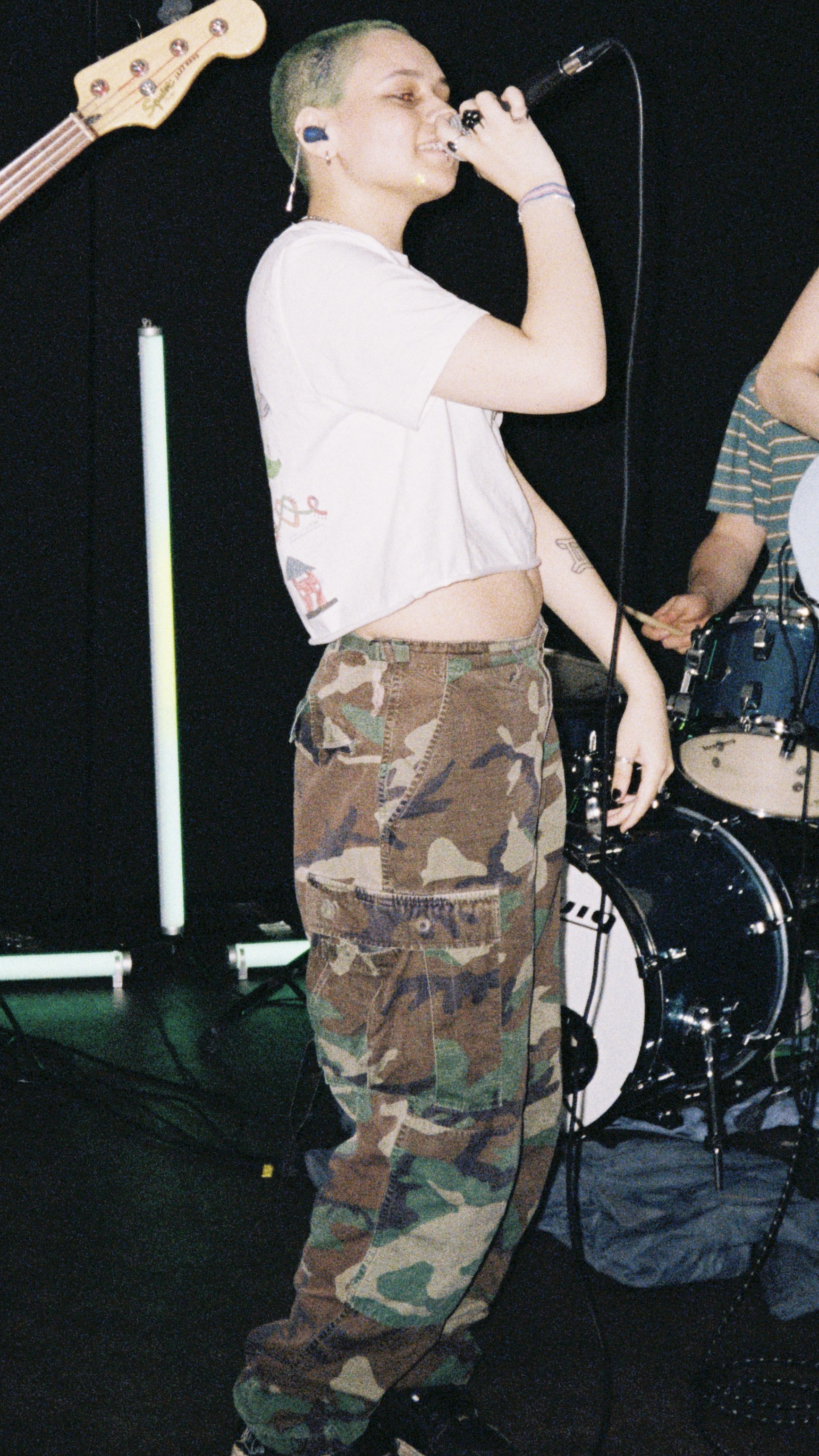 Xo FKA jayda on stage with a microphone in their hand held to their mouth.