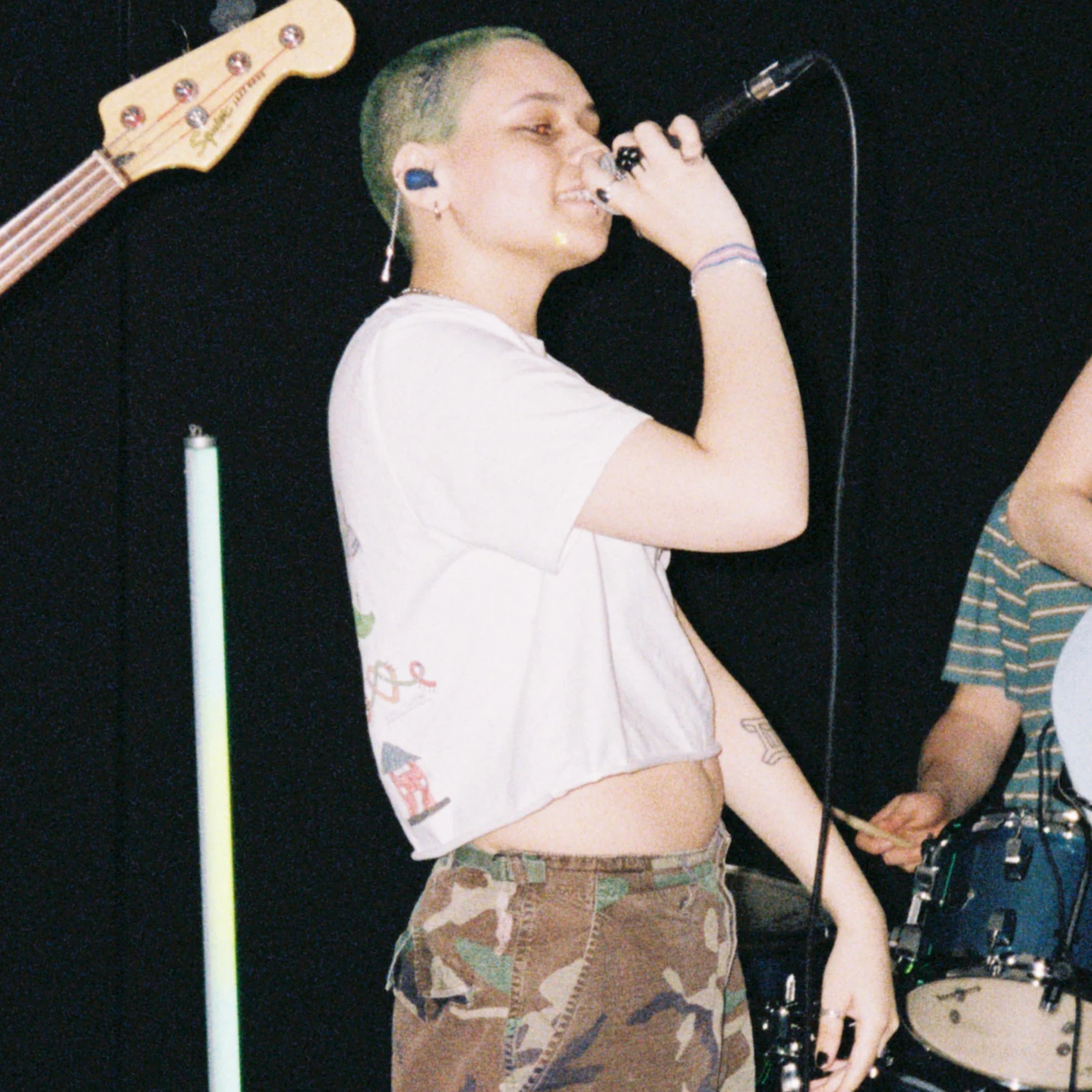 Xo FKA jayda on stage with a microphone in their hand held to their mouth.