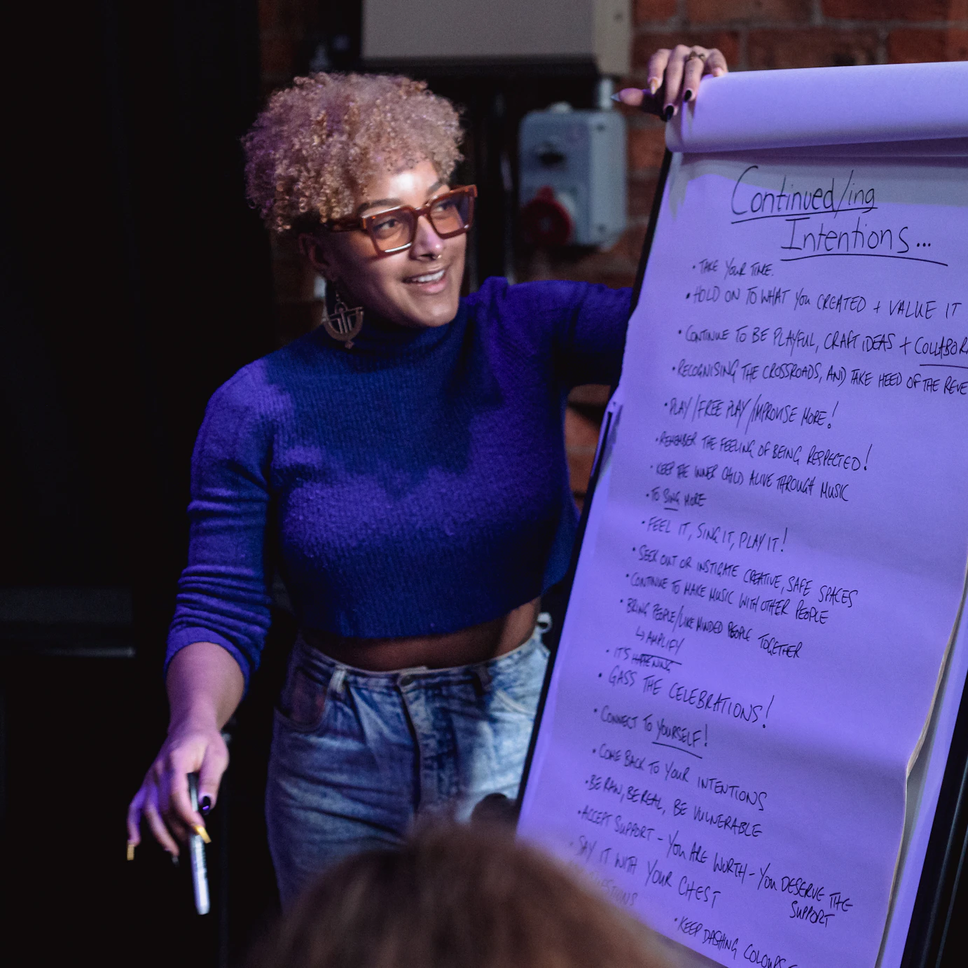 Nubya Garcia smiling and writing group intentions on a board.