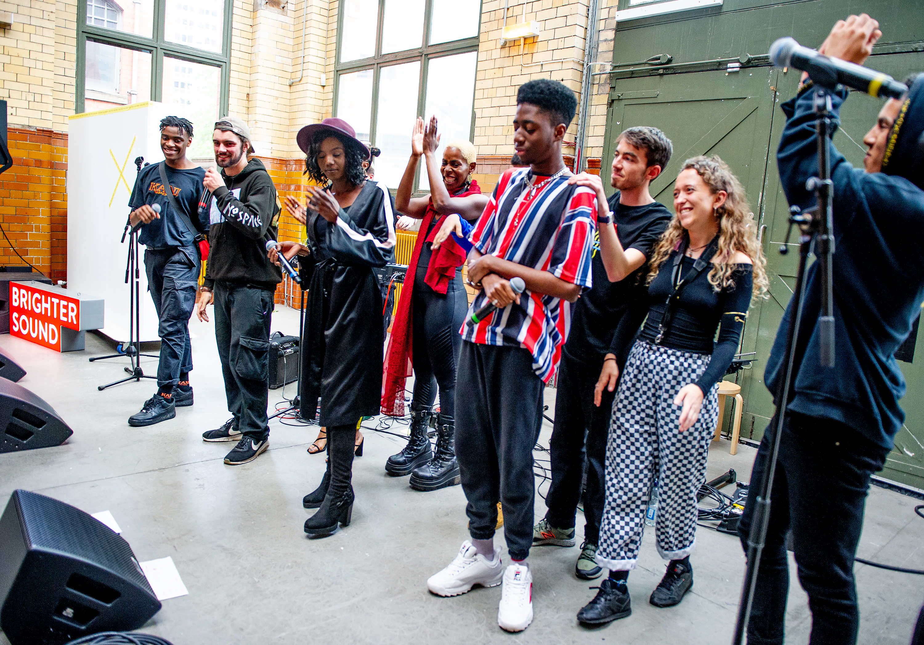 A group shot of all the DISRUPT participants clapping and smiling at the end of the performance.