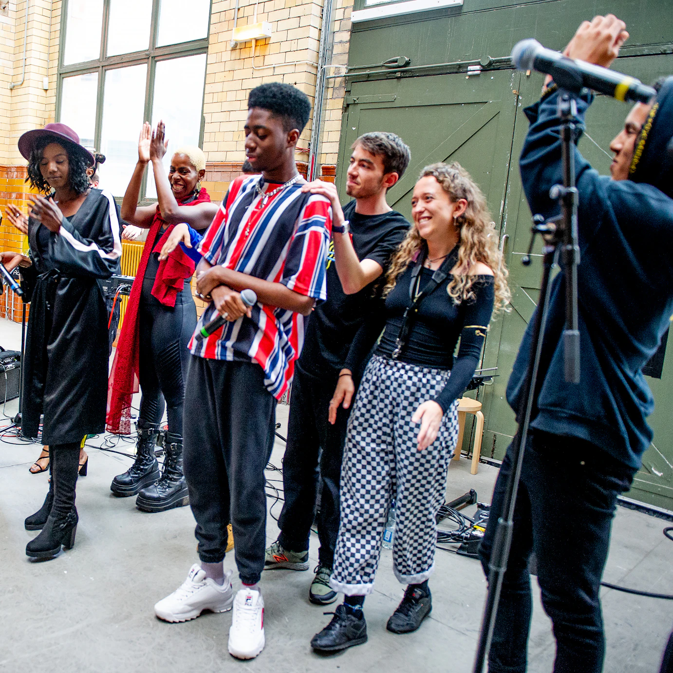 A group shot of all the DISRUPT participants clapping and smiling at the end of the performance.