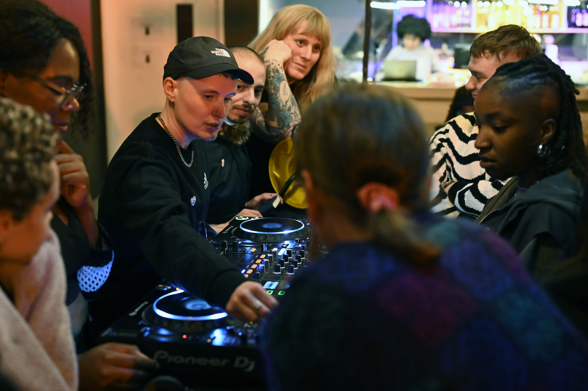 I. JORDAN and the residency artists gathered around DJ decks.