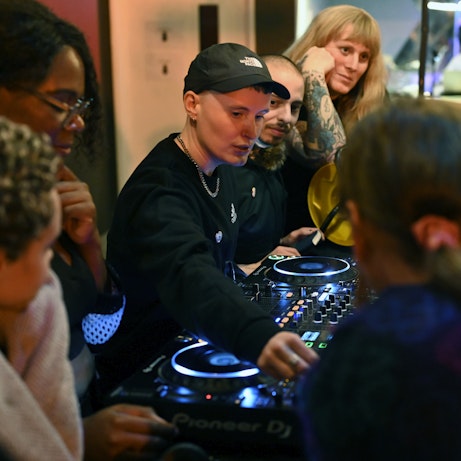 I. JORDAN and the residency artists gathered around DJ decks.