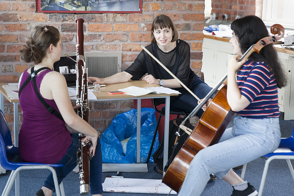 A visual artist and two musicians chatting.
