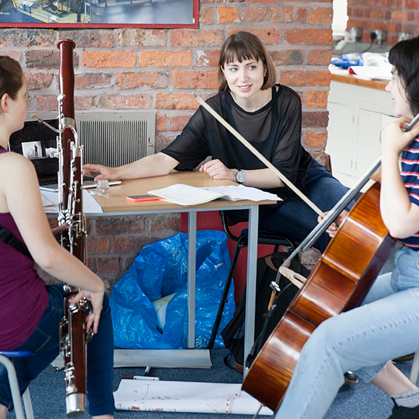 A visual artist and two musicians chatting.