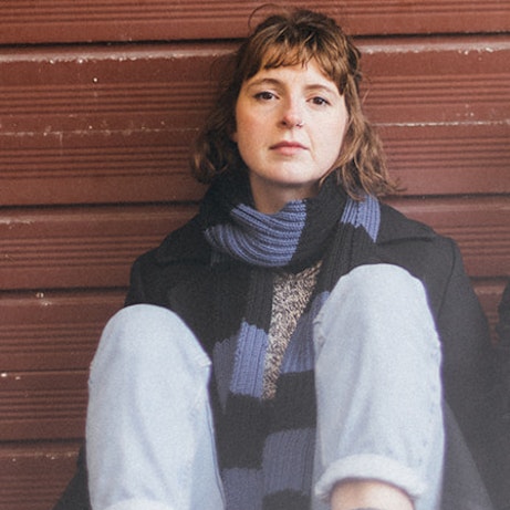 Francesca Knowles sat leaning against a brown wooden wall.