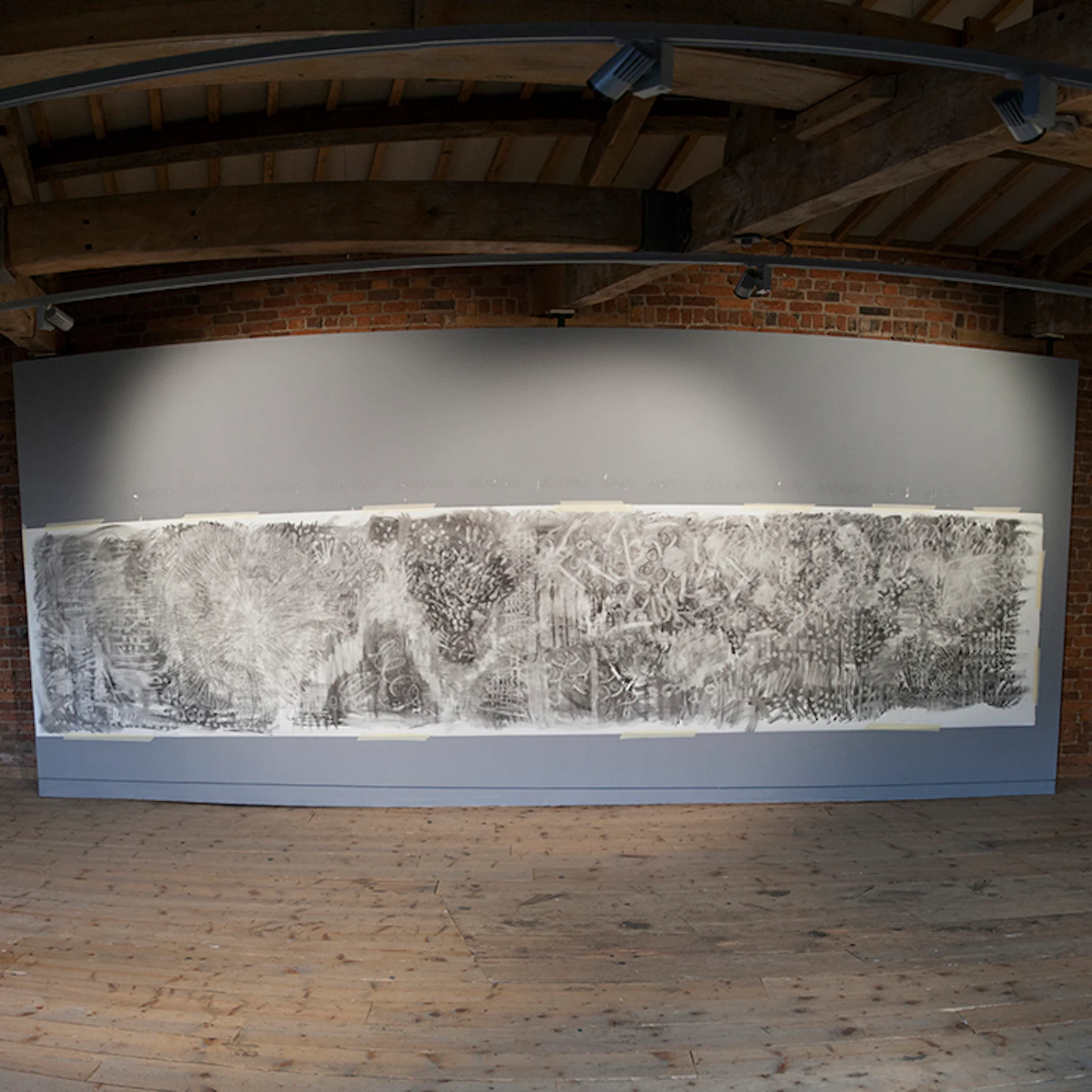 A charcoal artwork on a wall.
