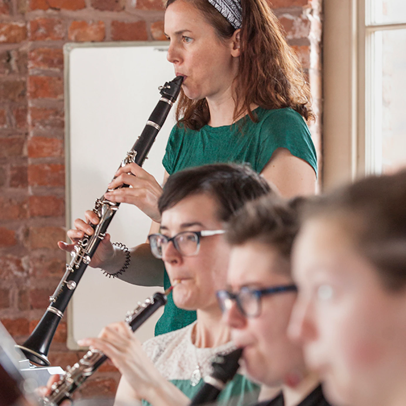 Anna Meredith playing flute alongside other musicians.