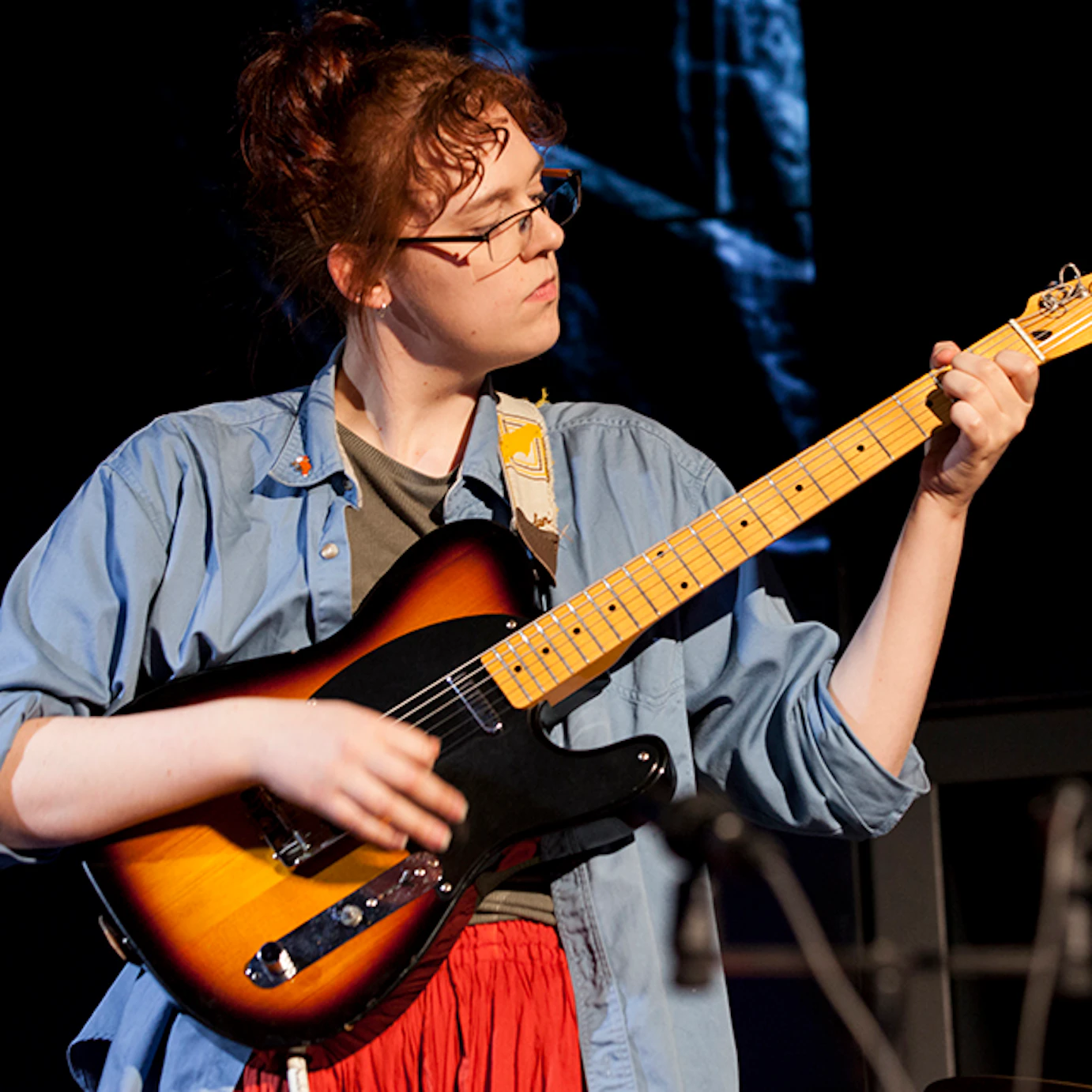 A musician playing guitar on stage.