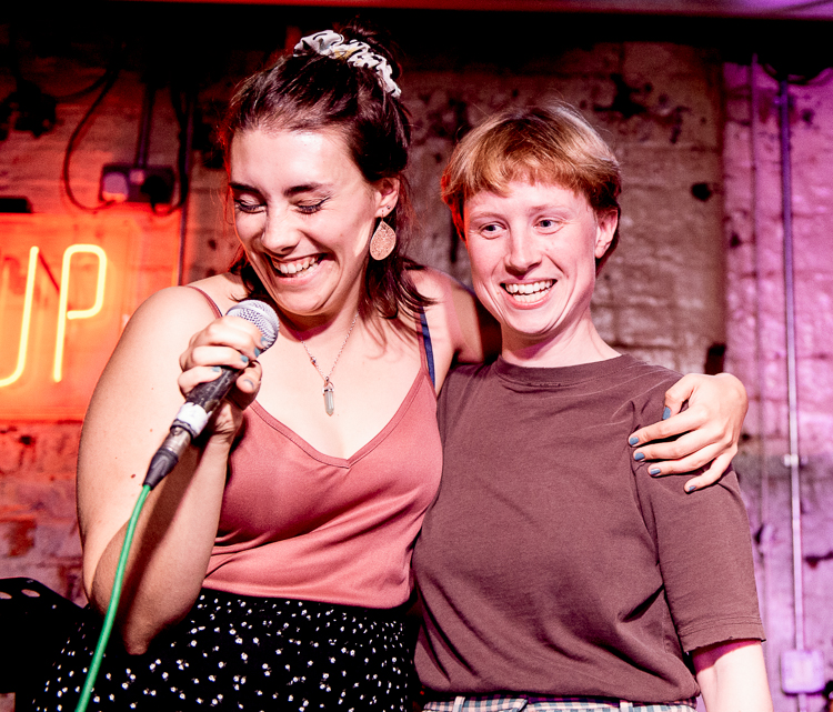 Caitlin and Ditte holding one another and smiling.
