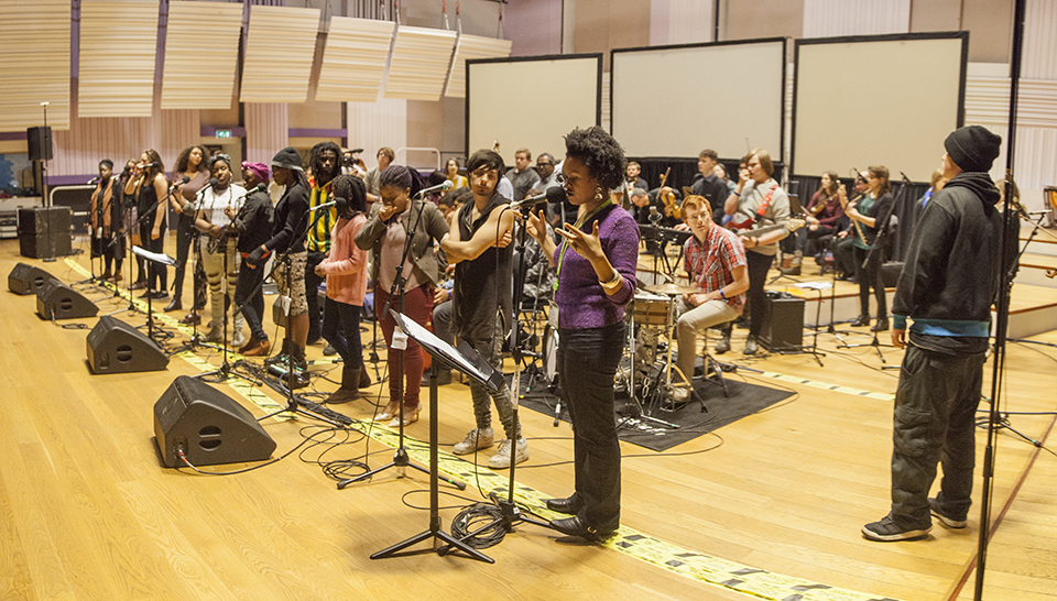 Meklit leading the musicians on stage.