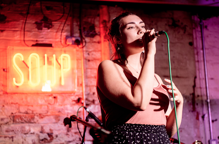 Caitlin singing into a mic.