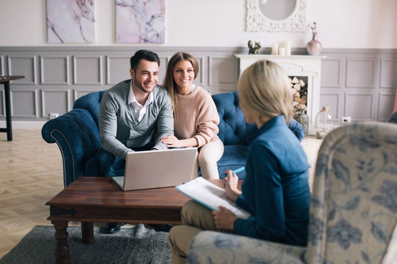 person interviewing a couple sitting on chairs 