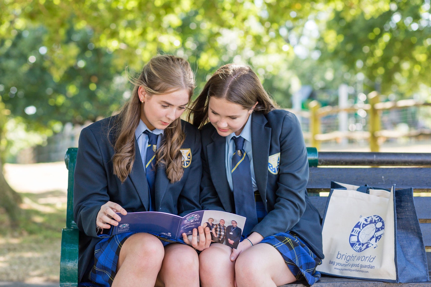 students reading Bright World brochure on bench