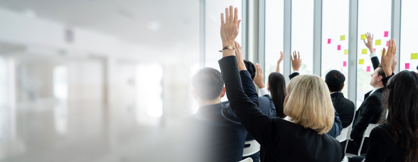 people in a class with hands up
