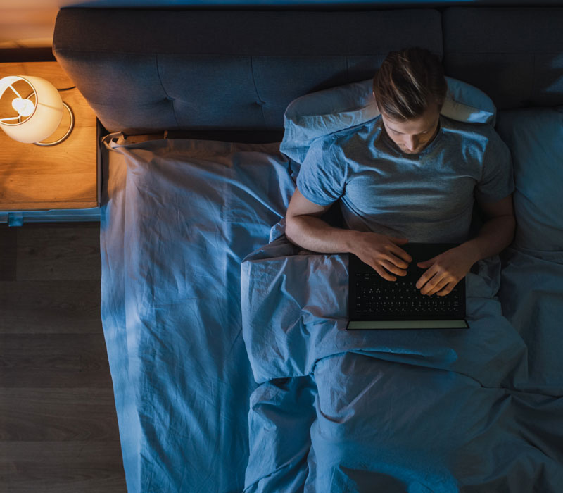 Boy on laptop in bed 