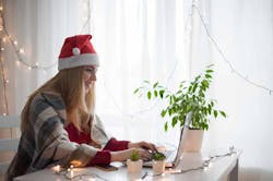 happy student at desk in Christmas hat 