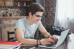 a young man studying on his laptop