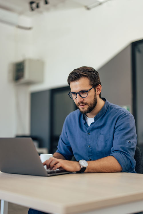 Man on computer looking intently 
