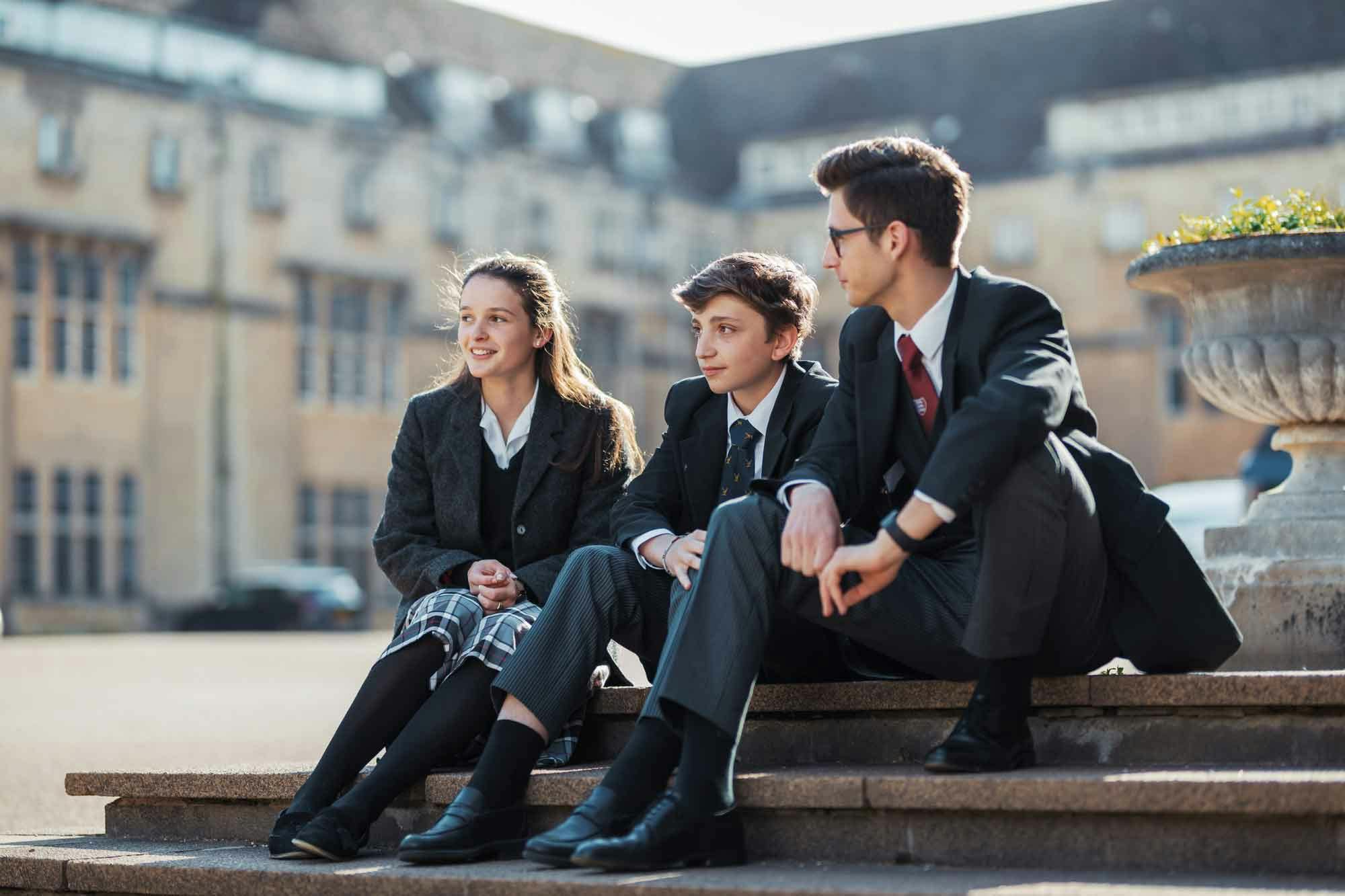 sixth form students on steps in uniform