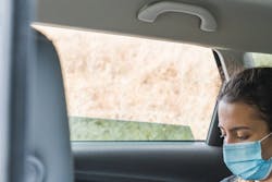 student in taxi with mask on