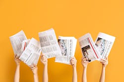 hands in the air with newspapers