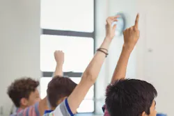 students in a class with hands up