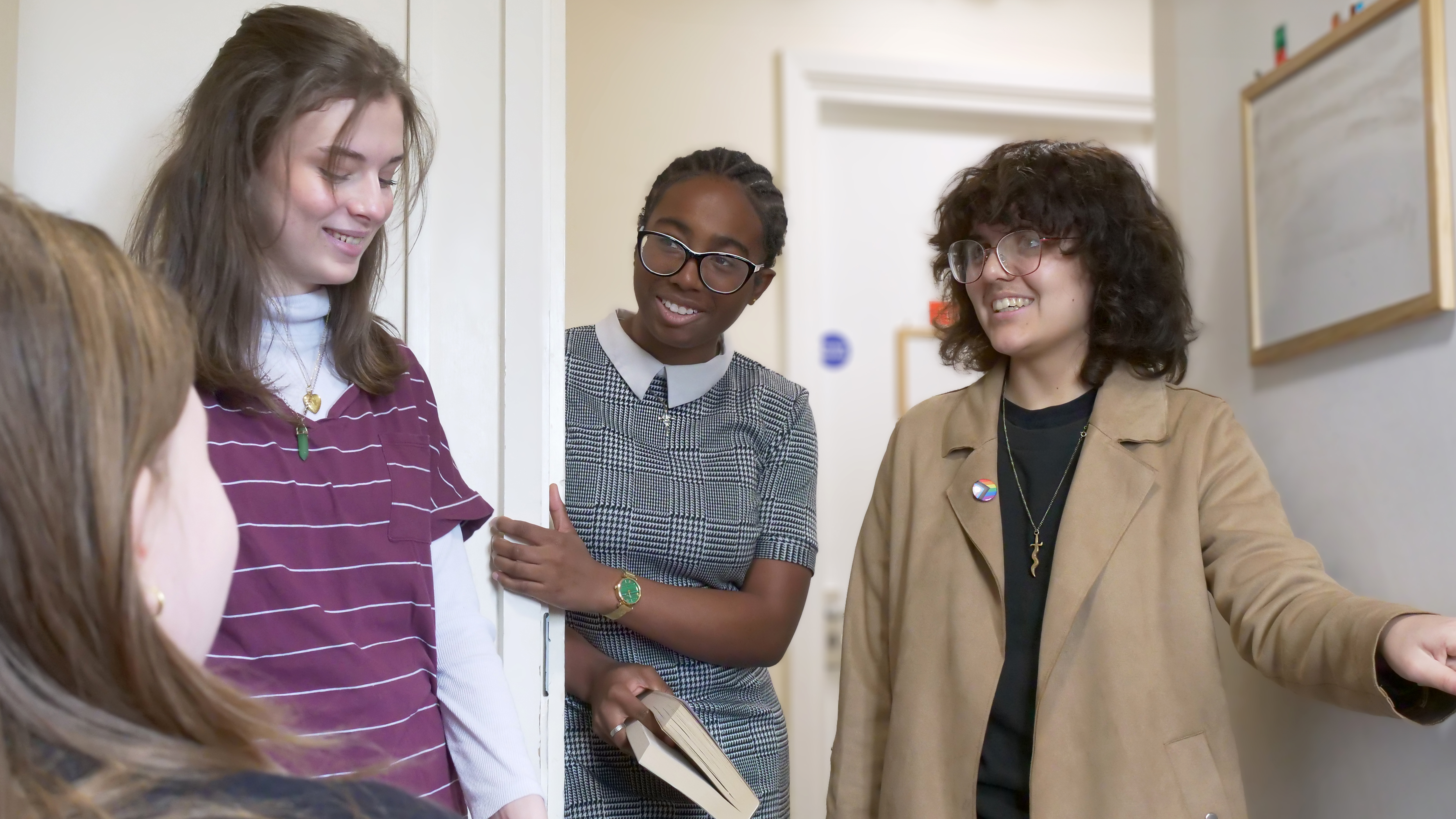 A group of students stood in a dormitory doorway talking to each other