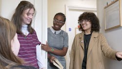 A group of students stood in a dormitory doorway talking to each other