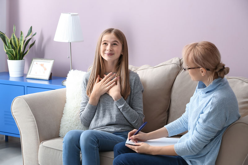 lady counselling girl who is smiling 