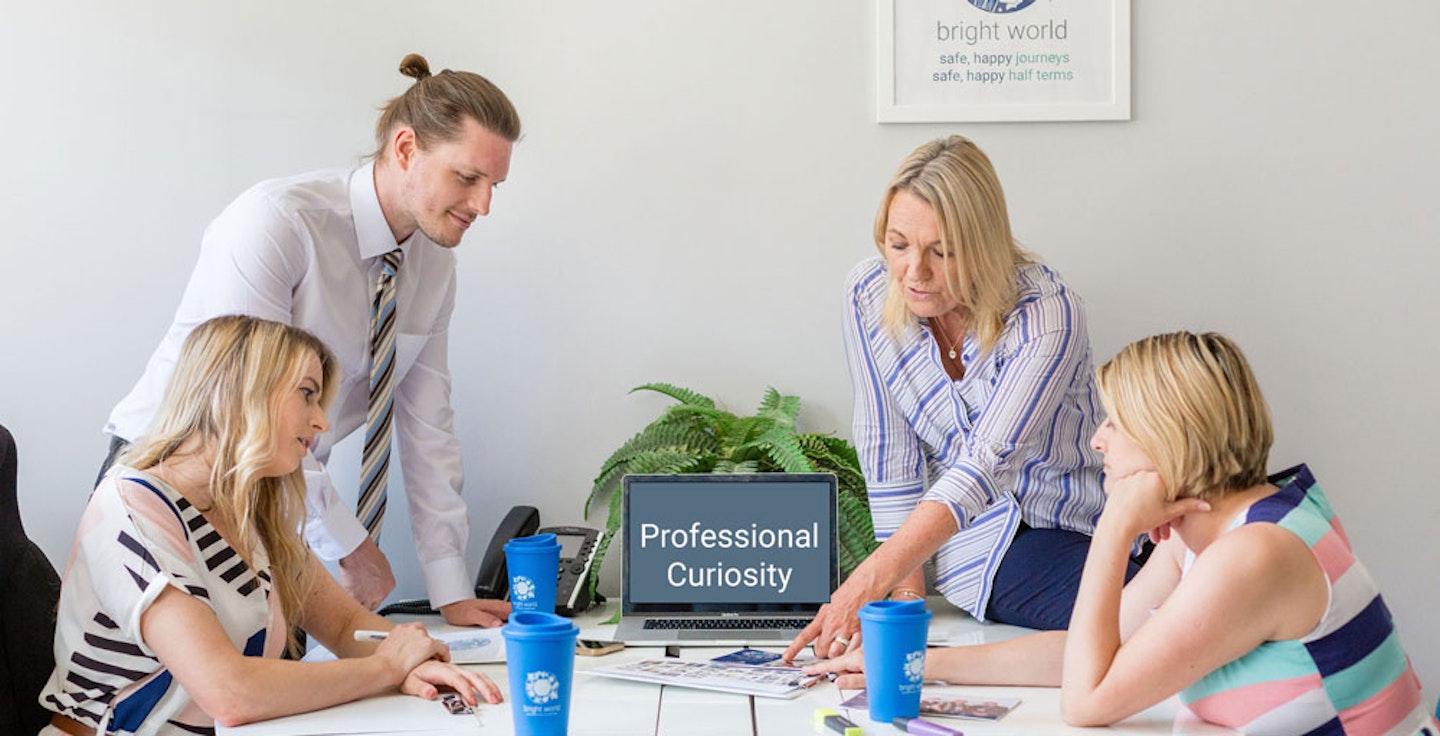 Team at desk looking at brochure
