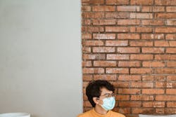 teenagers sitting on sofa socially distancing