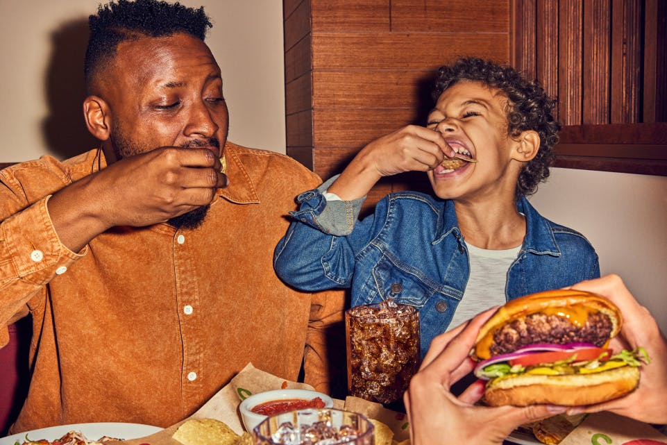 Kid and adult enjoying dinner at Chili's where Kids Eat Free