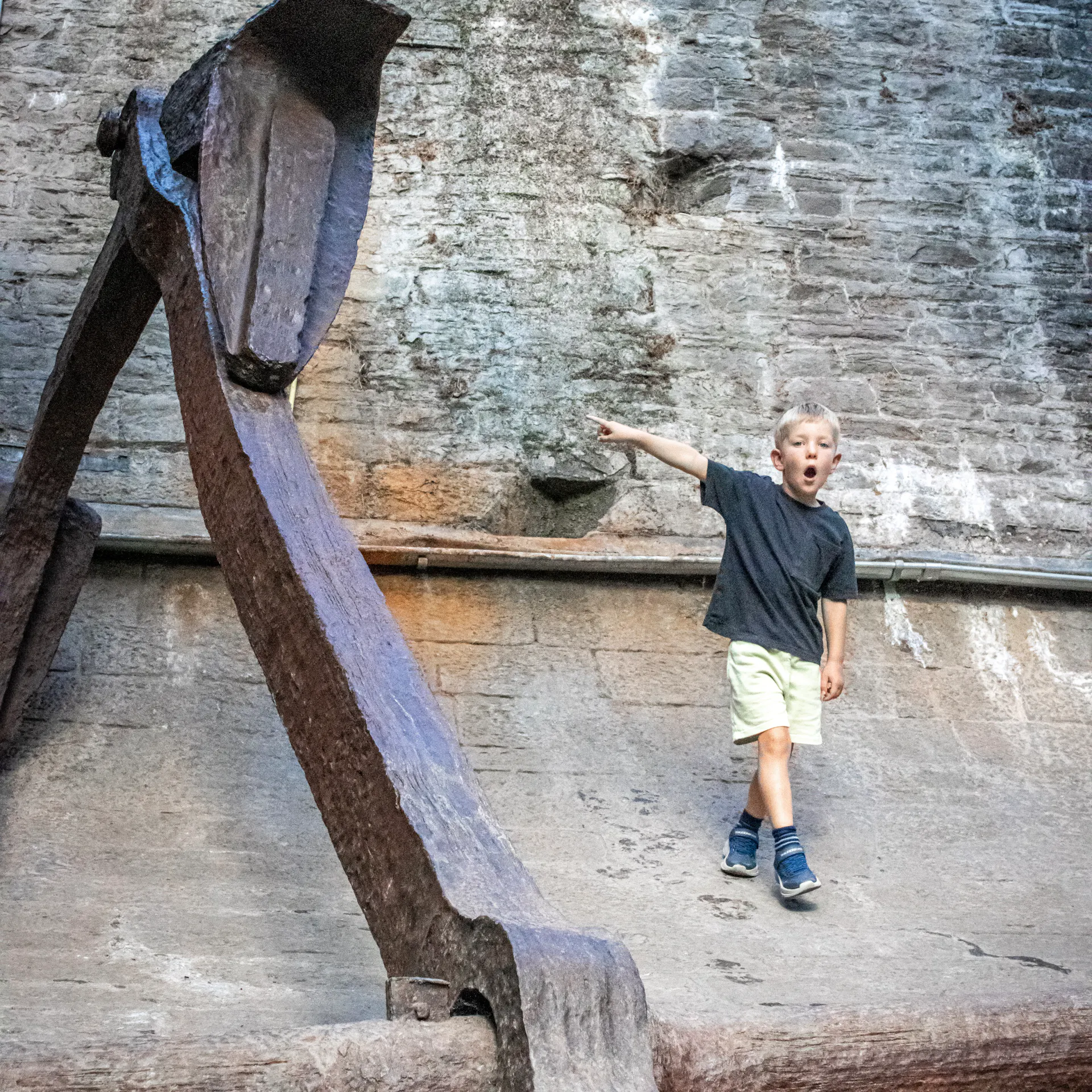 A child marvelling at the size of the anchor in the dry dock