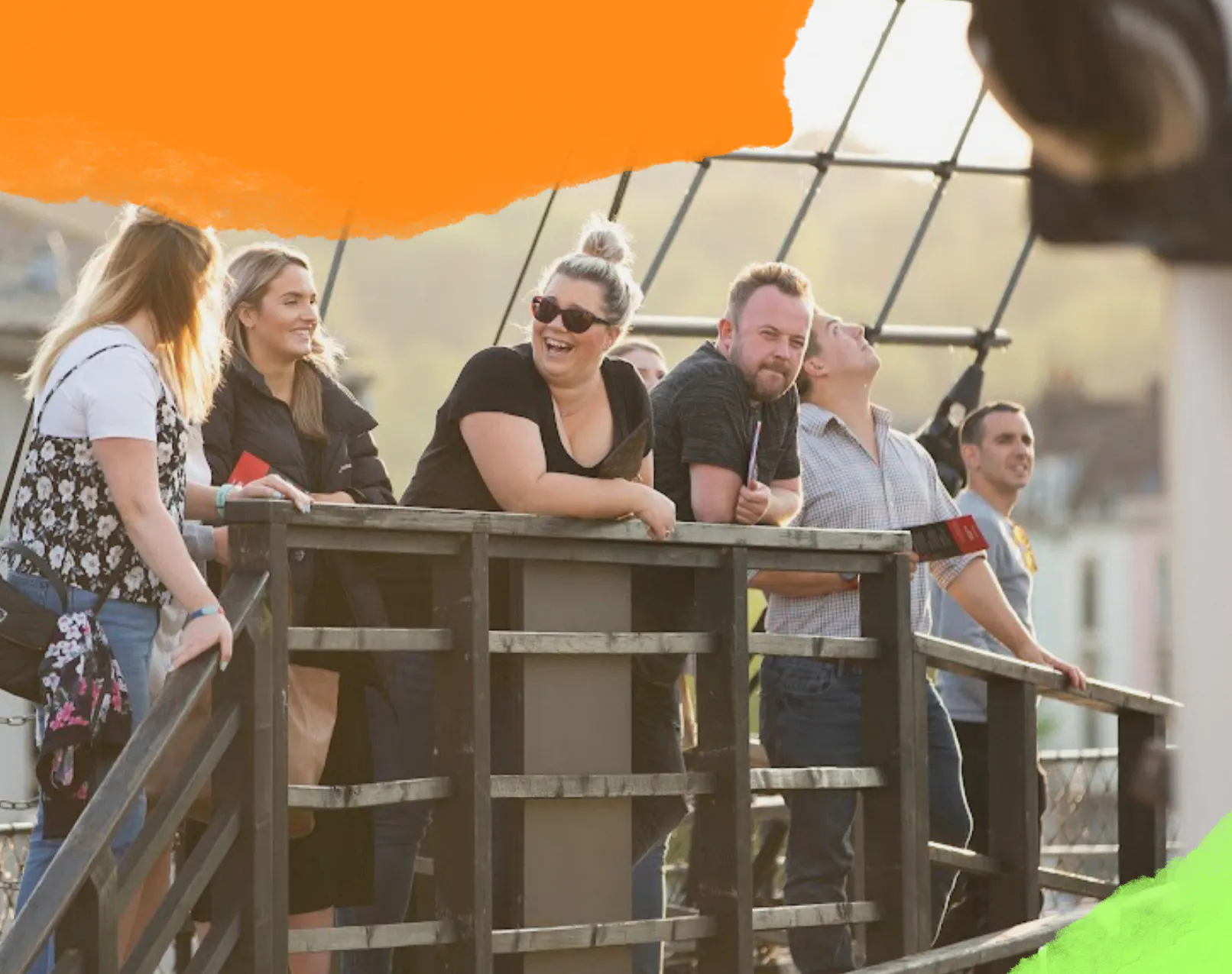 A group of adults visiting Bristol Dockyards are laughing in the sunshine