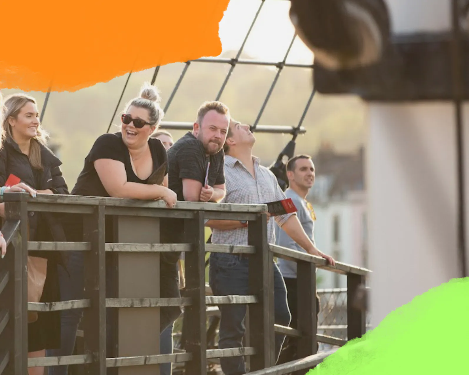 A group of adults visiting Bristol Dockyards are laughing in the sunshine