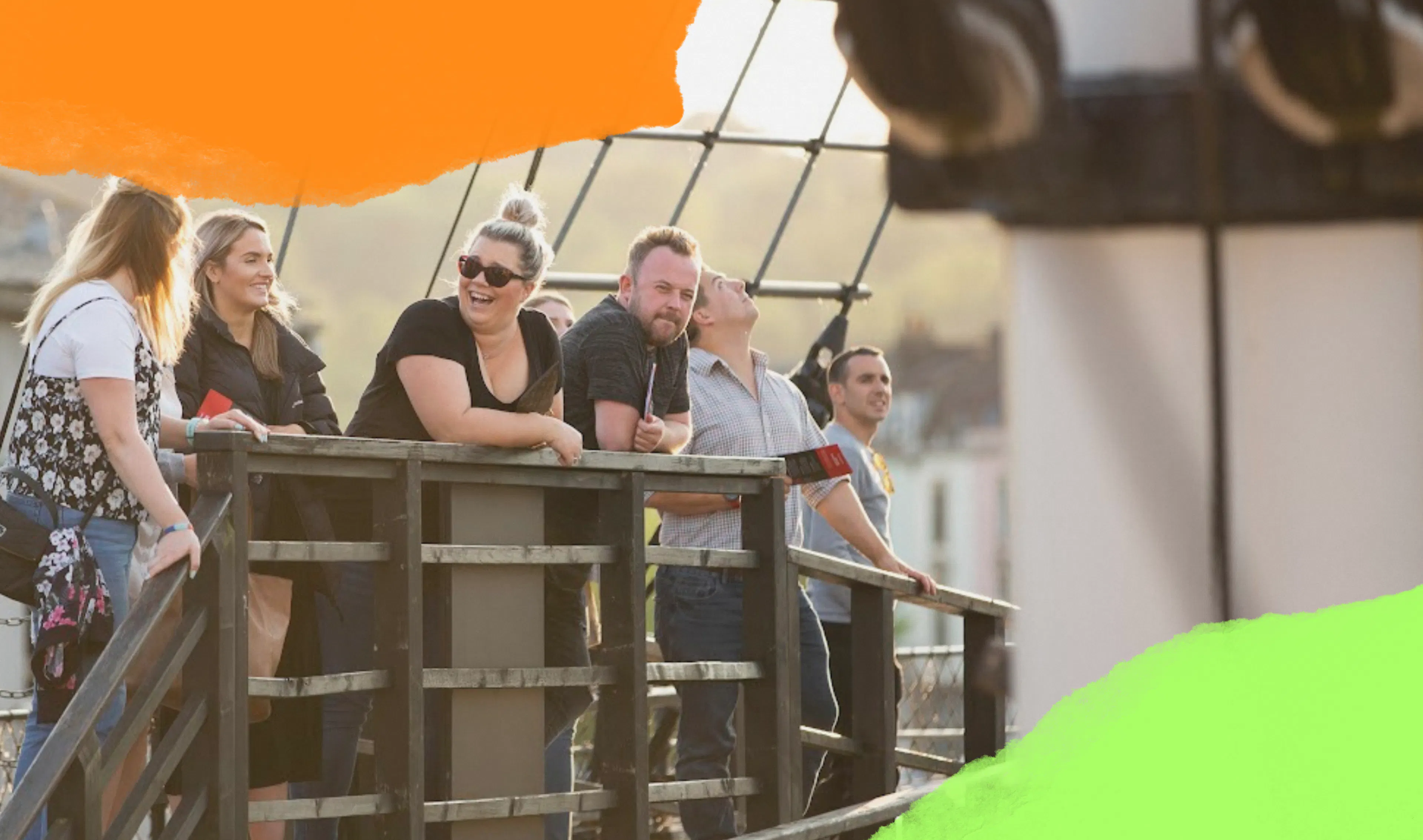 A group of adults visiting Bristol Dockyards are laughing in the sunshine